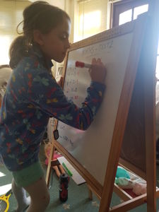 Emily doing some maths on the whiteboard