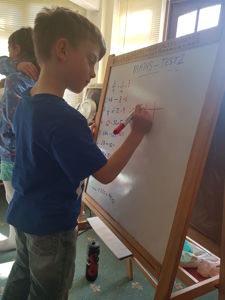 Tom doing some maths on the white board