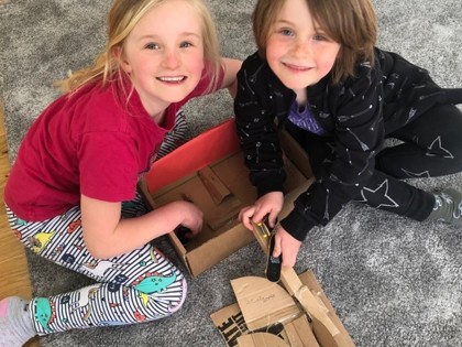 Olive and Corin have made a skate park out of cardboard boxes.