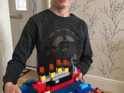 Max from Peake class with his Lego Titanic and a picture of the dragon he designed.